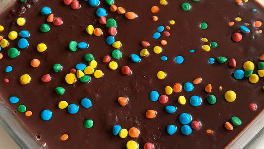 High protein cosmic brownies topped with chocolate ganache and rainbow candy gems