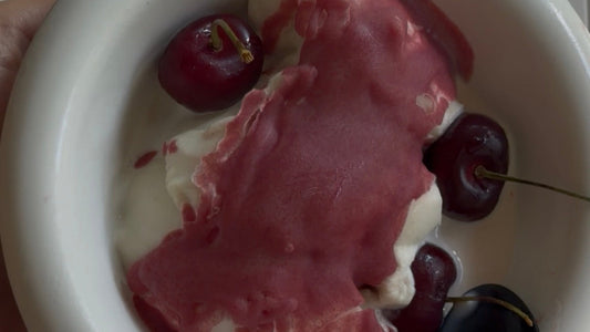Cherry dipped vanilla protein ice cream in a bowl with fresh cherries
