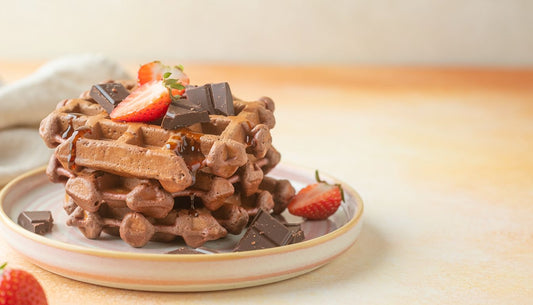 Chocolate protein waffles topped with strawberries and chocolate chunks