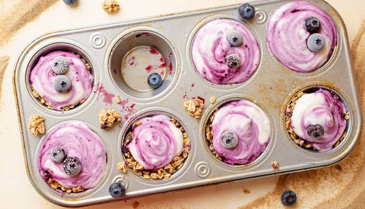 Frozen blueberry granola yogurt cups in a muffin tin