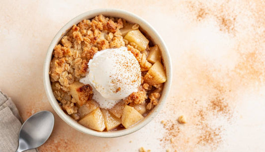 Single-serve apple crumble with oat topping and a scoop of vanilla ice cream