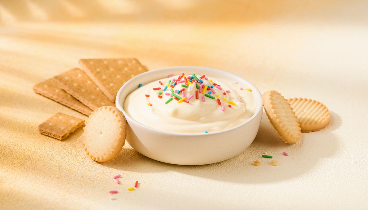 Creamy protein cheesecake dip with rainbow sprinkles and cookies for dipping