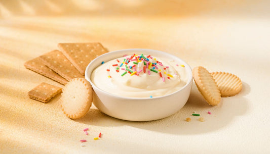 Creamy protein cheesecake dip with rainbow sprinkles and cookies for dipping