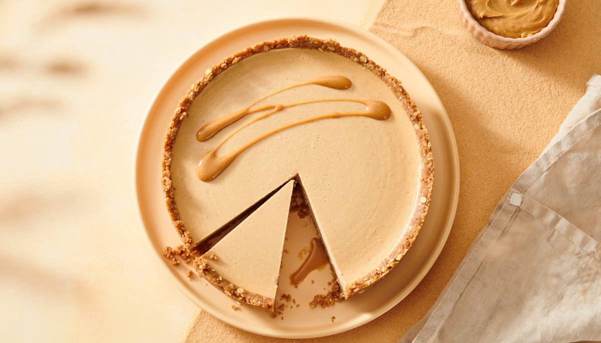 Vegan peanut butter protein cheesecake with an oat crust and a slice removed
