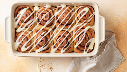 Vegan protein cinnamon rolls with cream cheese icing in a baking dish